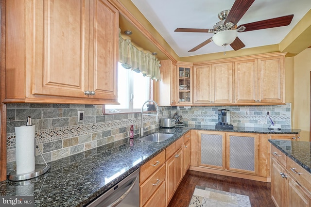 kitchen featuring sink, dark stone countertops, dark hardwood / wood-style floors, tasteful backsplash, and stainless steel dishwasher