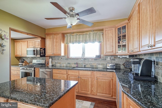 kitchen with sink, backsplash, stainless steel appliances, dark hardwood / wood-style flooring, and dark stone counters