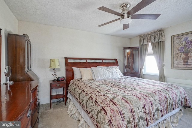 carpeted bedroom with ceiling fan and a textured ceiling