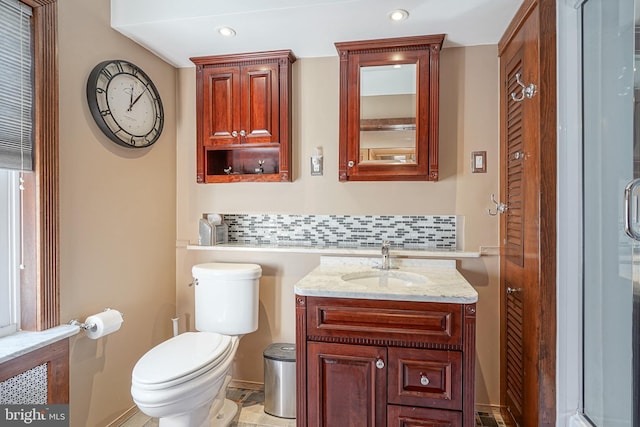 bathroom featuring vanity, toilet, an enclosed shower, and backsplash