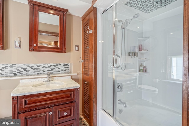 bathroom featuring tasteful backsplash, vanity, and shower / bath combination with glass door