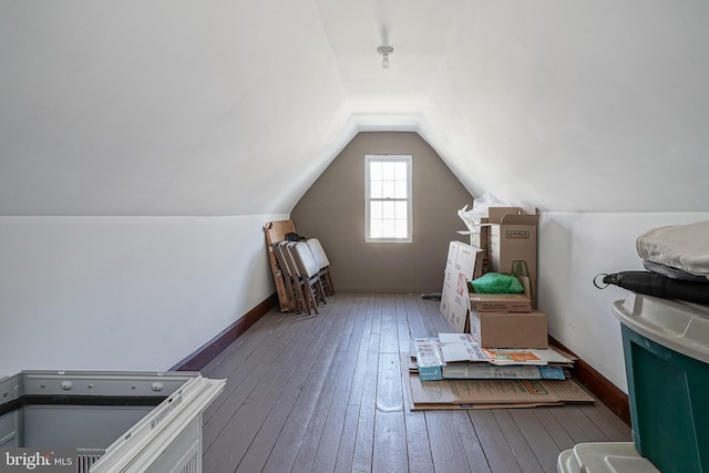 additional living space with lofted ceiling and hardwood / wood-style floors