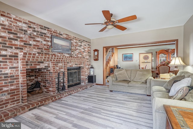 living room featuring light carpet, a fireplace, and ceiling fan