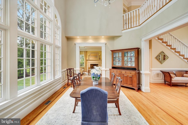 dining room featuring hardwood / wood-style flooring, a chandelier, and a high ceiling