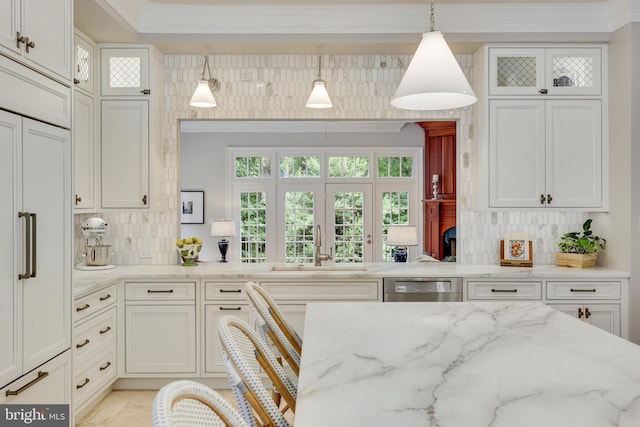 kitchen with crown molding, backsplash, a sink, light stone countertops, and dishwasher