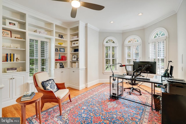 office featuring plenty of natural light, ornamental molding, ceiling fan, and light wood-type flooring