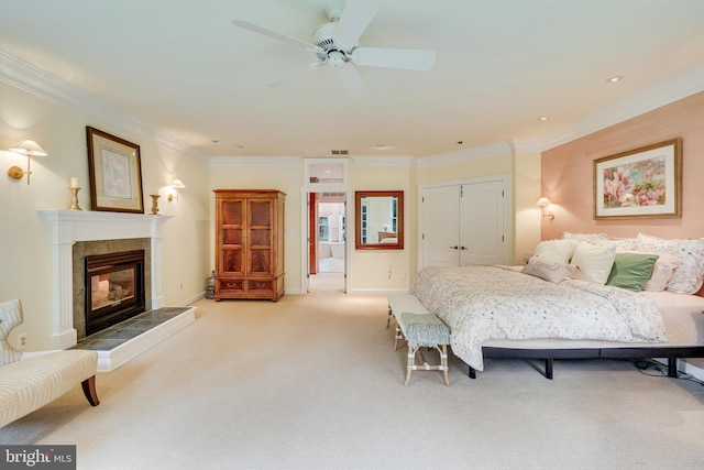 bedroom with a fireplace, ornamental molding, a closet, and light colored carpet