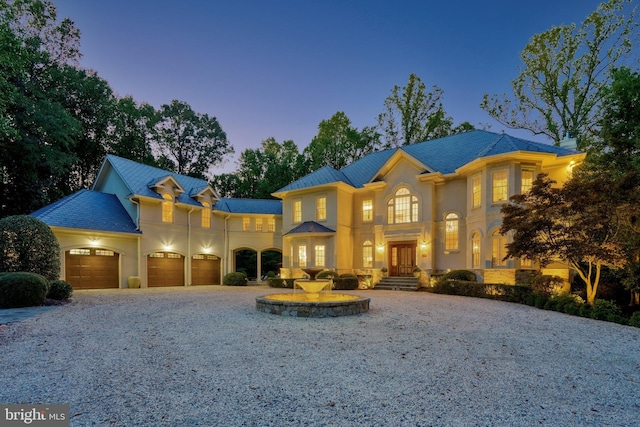 view of front facade with a garage, french doors, driveway, and stucco siding