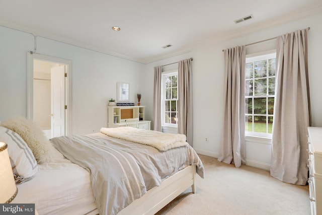 bedroom with multiple windows, visible vents, crown molding, and light colored carpet