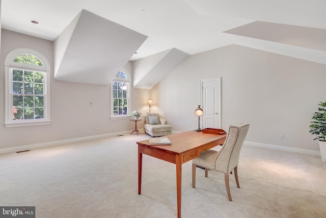 office space featuring light carpet, baseboards, visible vents, and vaulted ceiling