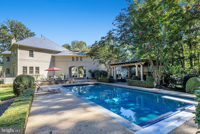 view of swimming pool featuring a pergola, a diving board, and a patio area