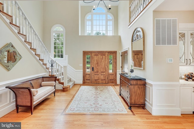 foyer entrance featuring a notable chandelier and light wood-type flooring