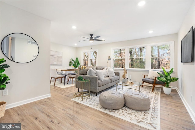 living room featuring plenty of natural light, ceiling fan, and light wood-type flooring