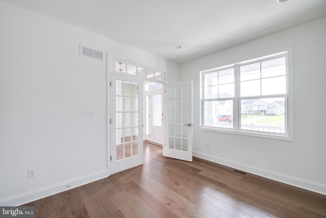 unfurnished room with hardwood / wood-style floors and french doors