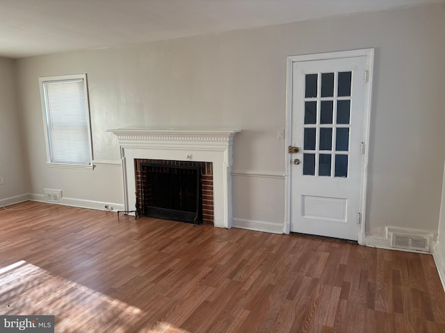 unfurnished living room with a fireplace and wood-type flooring