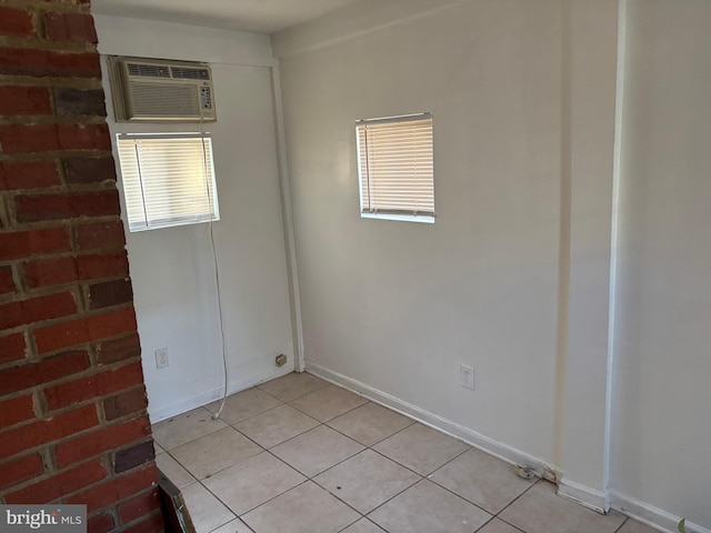 tiled spare room with an AC wall unit