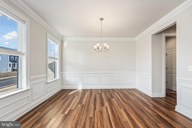 empty room with a notable chandelier, crown molding, and dark hardwood / wood-style floors