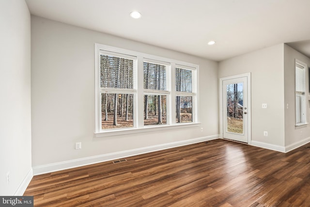 unfurnished dining area featuring dark wood-type flooring