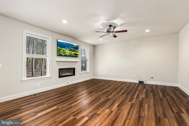 unfurnished living room featuring dark hardwood / wood-style flooring and ceiling fan