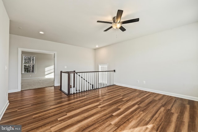 unfurnished room featuring dark wood-type flooring and ceiling fan