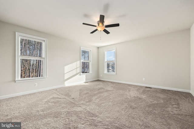 carpeted spare room featuring ceiling fan