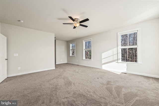 carpeted spare room featuring ceiling fan