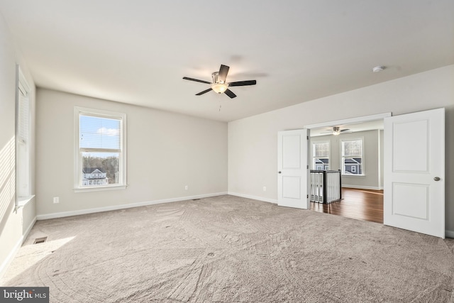 interior space with ceiling fan and dark colored carpet