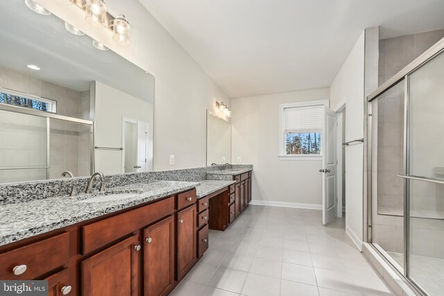 bathroom with tile patterned floors, vanity, and a shower with door