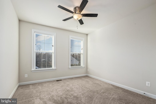 carpeted spare room with a healthy amount of sunlight and ceiling fan