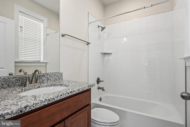 full bathroom with vanity, tiled shower / bath combo, and toilet