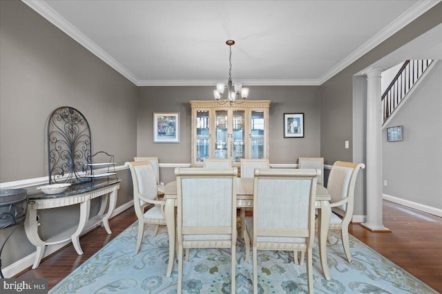 dining space featuring baseboards, ornamental molding, wood finished floors, and an inviting chandelier