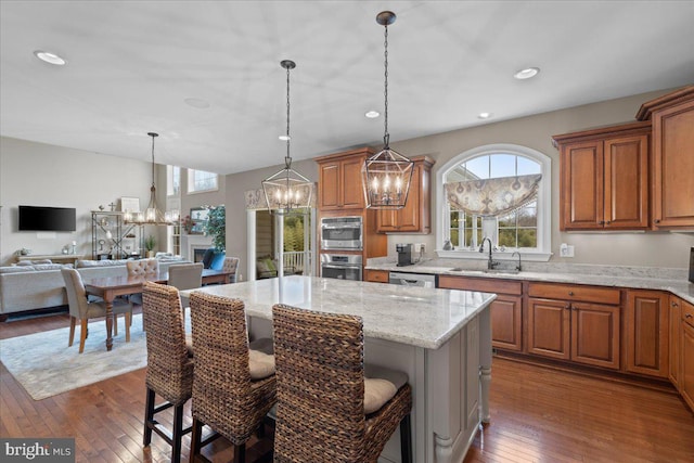 kitchen with appliances with stainless steel finishes, brown cabinets, a sink, and a chandelier