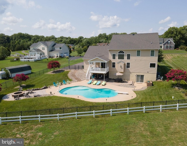 back of house with a lawn, an outdoor fire pit, a fenced backyard, a wooden deck, and stairs