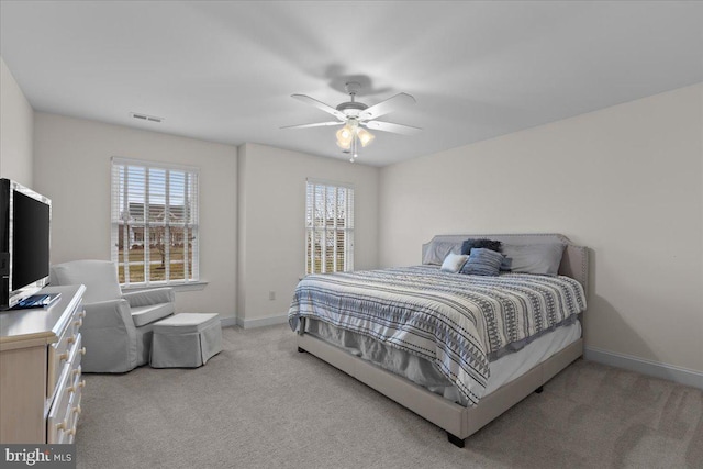 bedroom featuring baseboards, a ceiling fan, visible vents, and light colored carpet