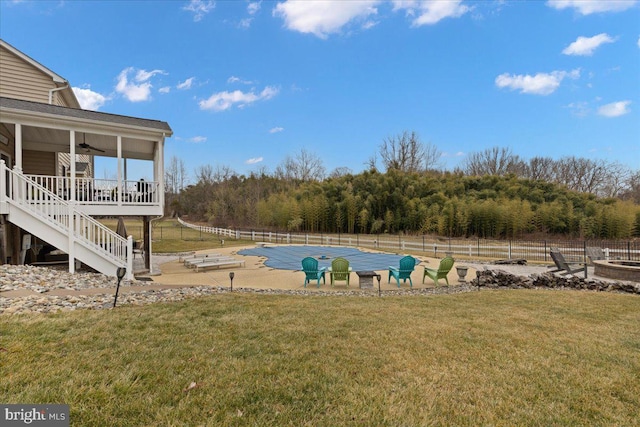 view of yard featuring a fenced in pool, a ceiling fan, stairway, fence, and a patio area