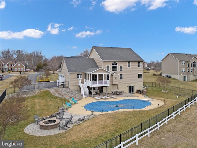 view of swimming pool featuring a patio, a lawn, stairway, a fenced backyard, and a fire pit