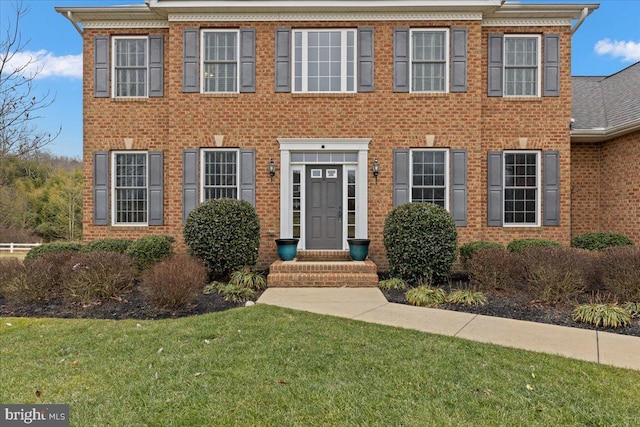 view of front of house featuring a front lawn and brick siding