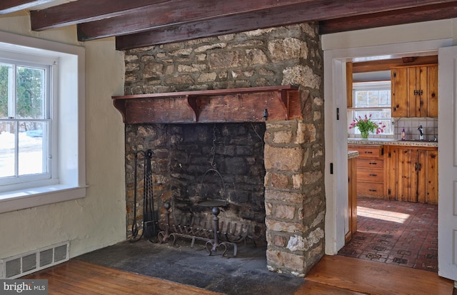 details featuring a stone fireplace, sink, and decorative backsplash