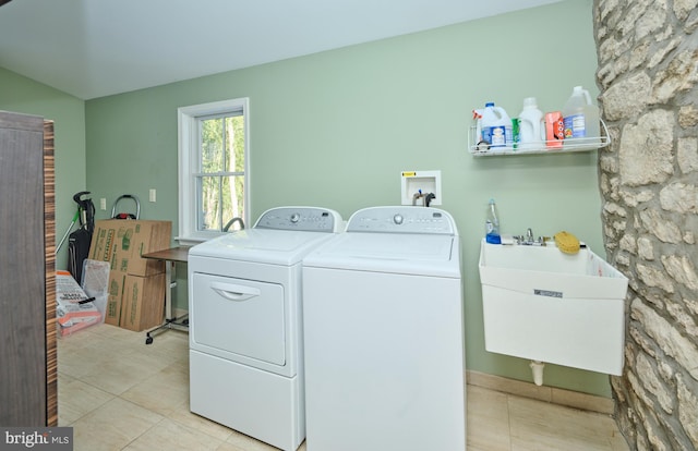 washroom with washing machine and dryer, sink, and light tile patterned flooring