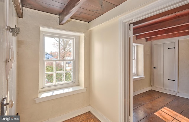 corridor with wood-type flooring, beam ceiling, and wooden ceiling