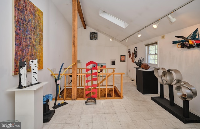 interior space with lofted ceiling with skylight and rail lighting