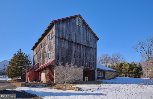 view of snowy exterior featuring an outbuilding