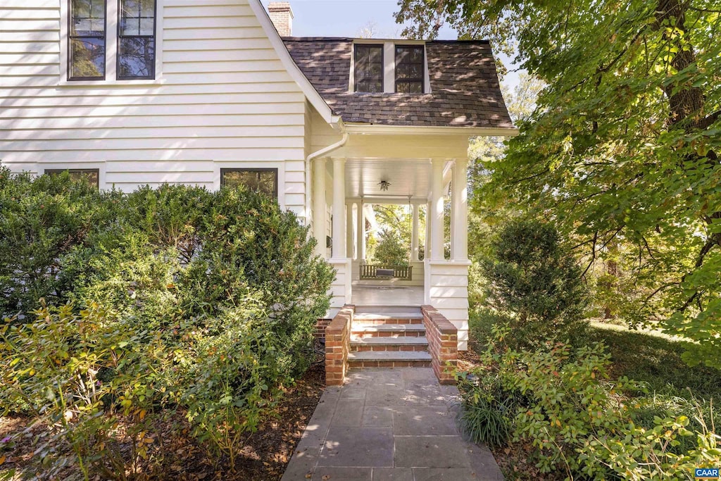 view of exterior entry featuring covered porch