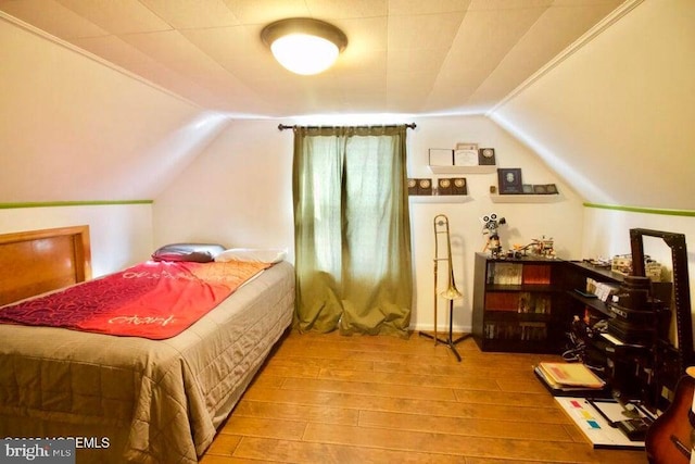 bedroom featuring hardwood / wood-style flooring and vaulted ceiling