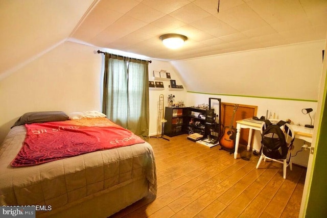 bedroom with hardwood / wood-style flooring and lofted ceiling