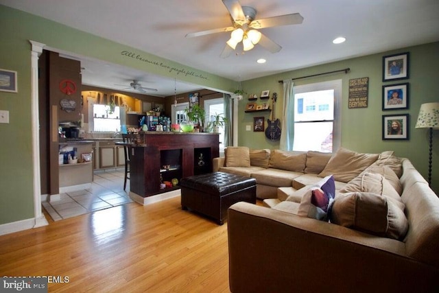 living room with ceiling fan and light wood-type flooring