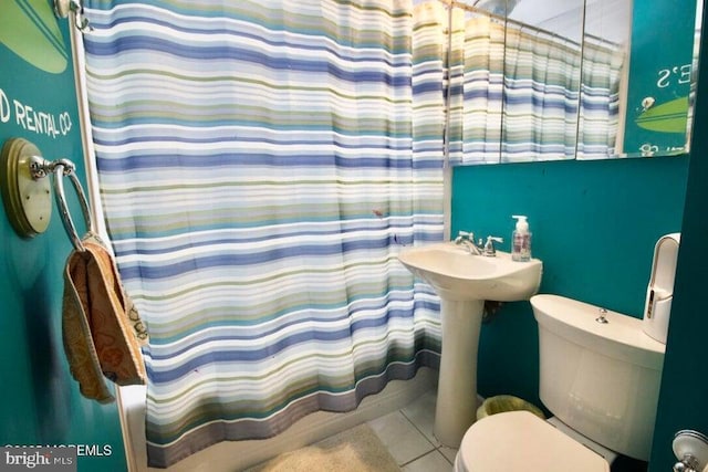 full bathroom with shower / bath combo, sink, tile patterned floors, and toilet