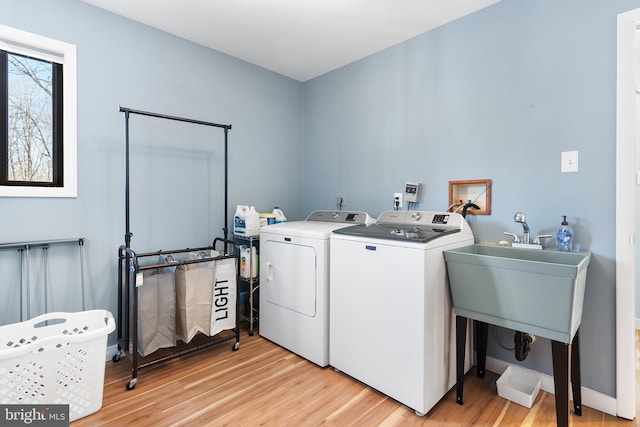 laundry area with washer and clothes dryer and light hardwood / wood-style flooring