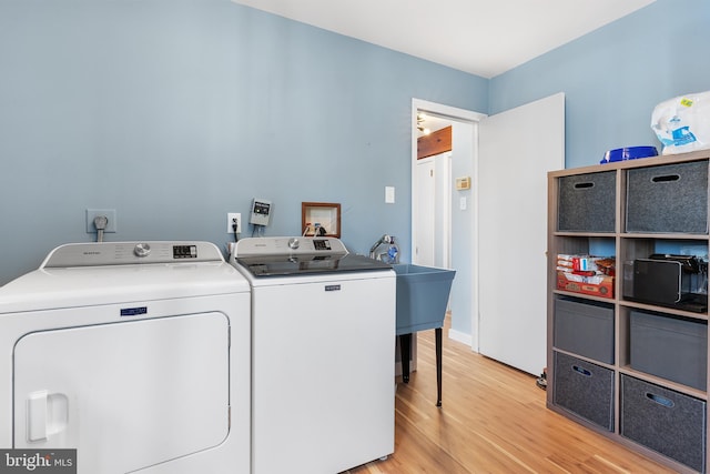 washroom featuring washer and clothes dryer and light wood-type flooring