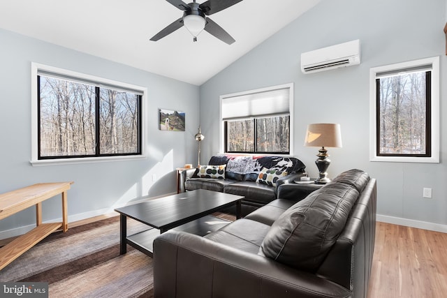 living room featuring ceiling fan, vaulted ceiling, light hardwood / wood-style floors, and a wall mounted AC